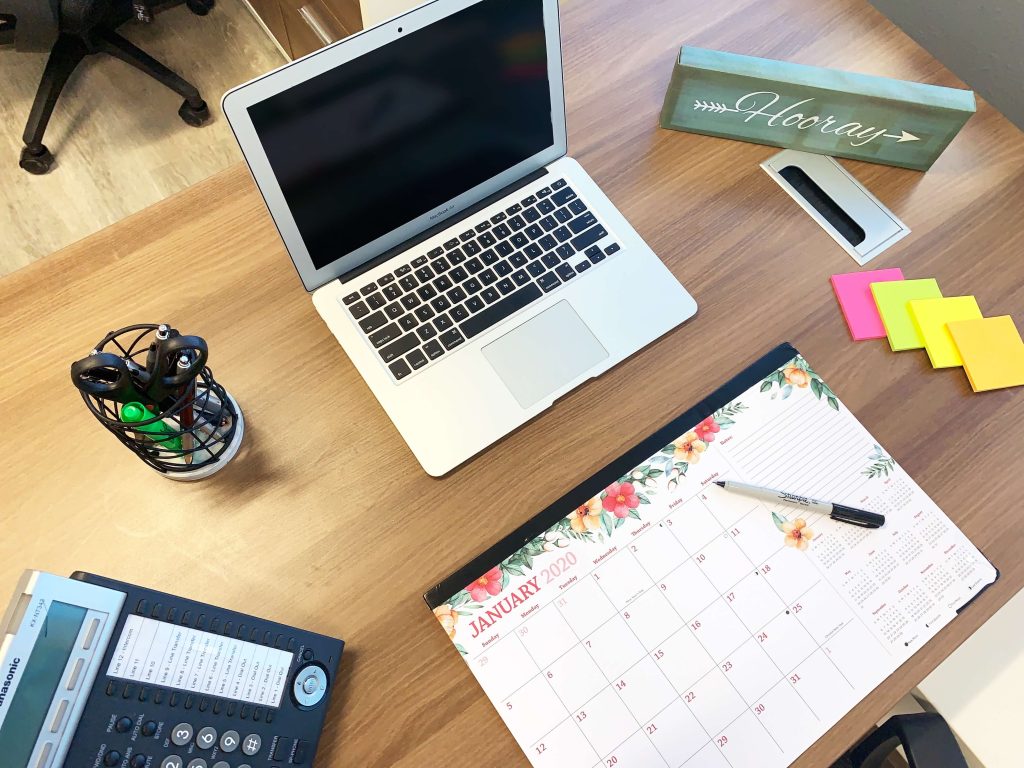 Laptop on desk with calendar in front of it
