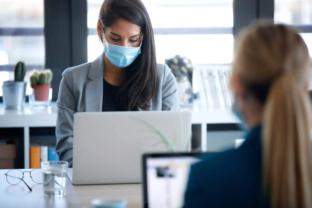 Woman in coworking space wearing face mask