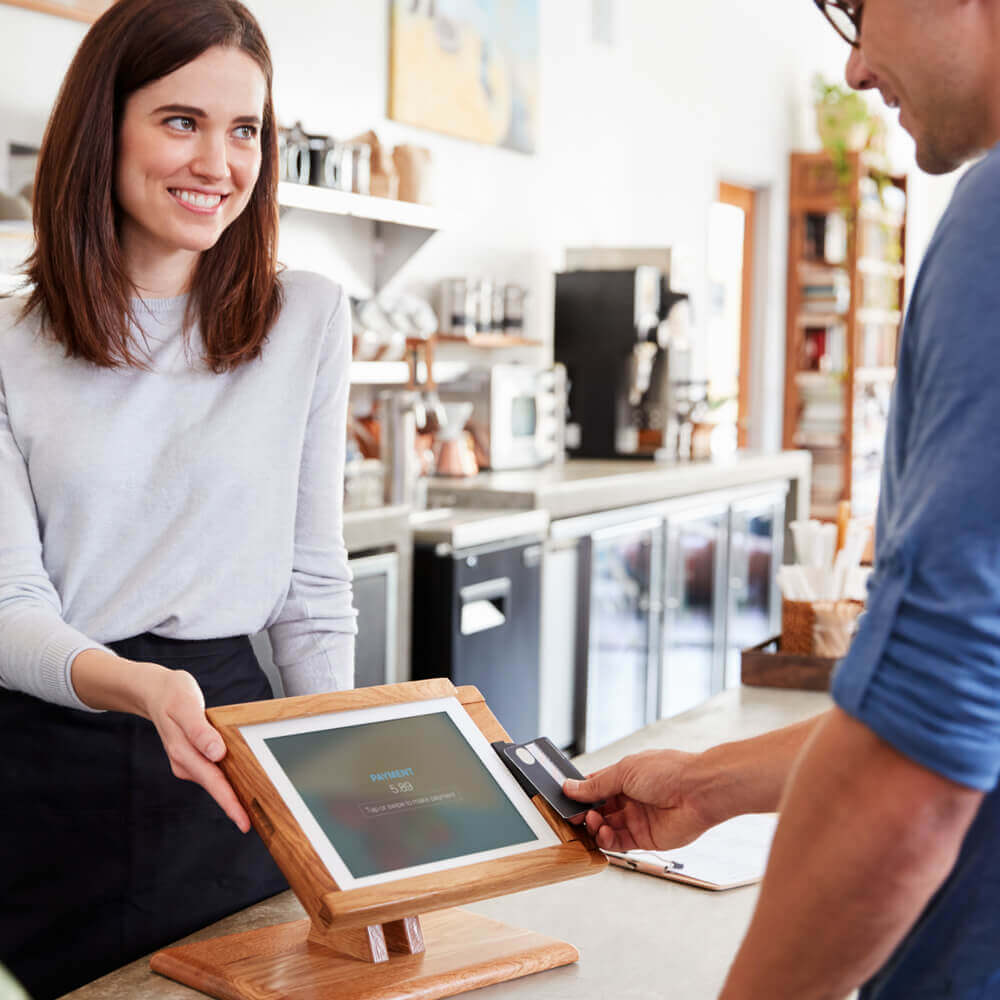 Man using contactless card system to pay at cafe