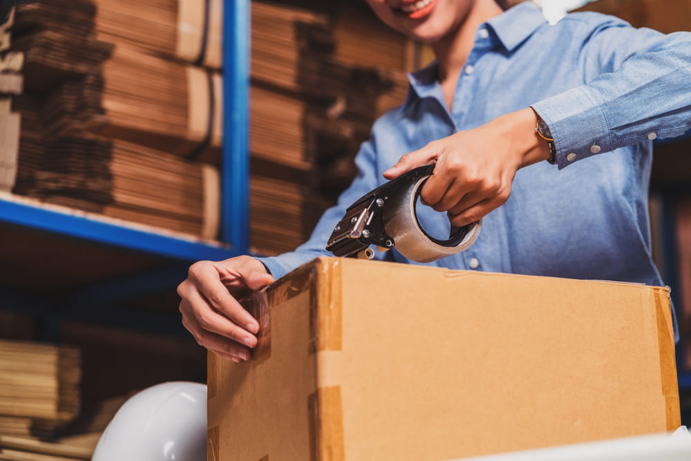 Woman packing box at warehouse space