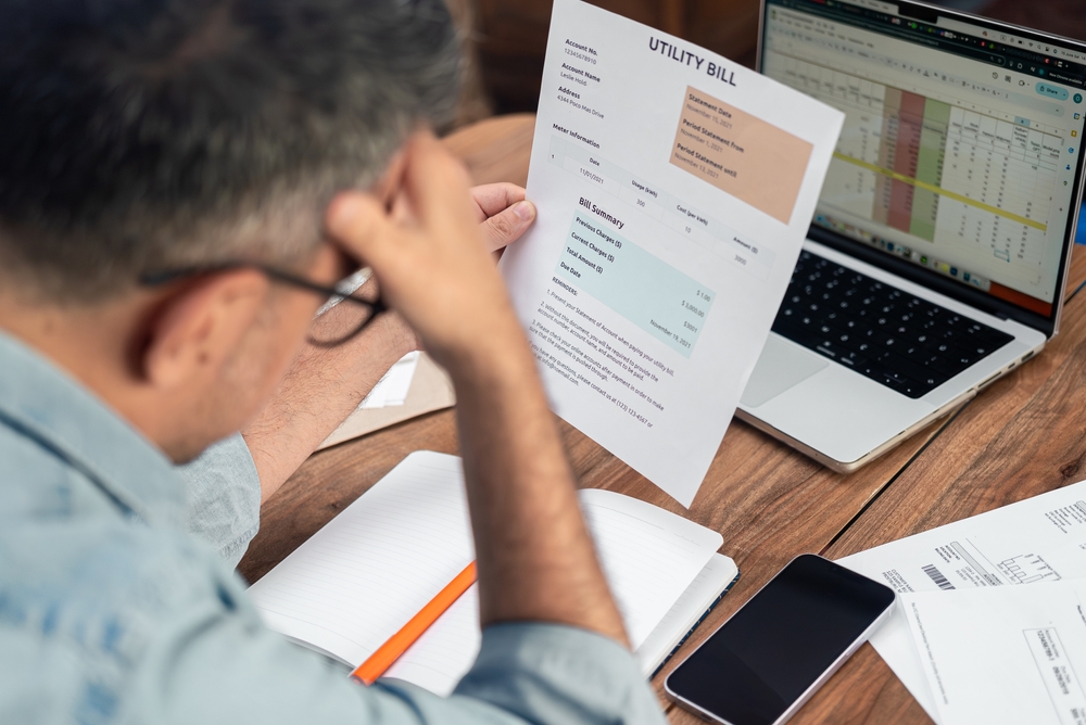 Man looking at workspace utility bill