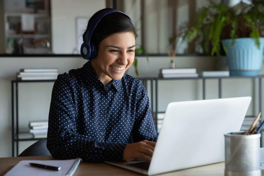 Woman smiling at laptop in office