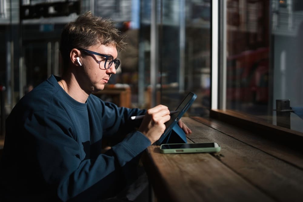 Freelancer working at coworking space with earbud in