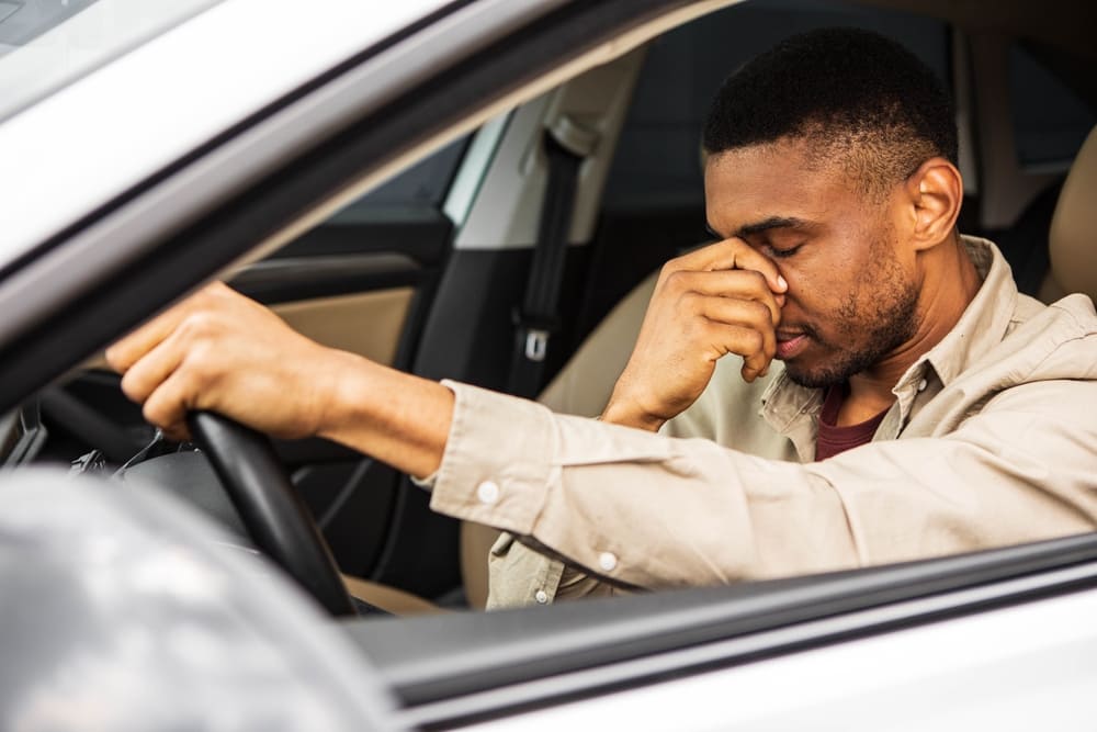 Man in car stuck in traffic on commute, wishing he was at a Northridge coworking space
