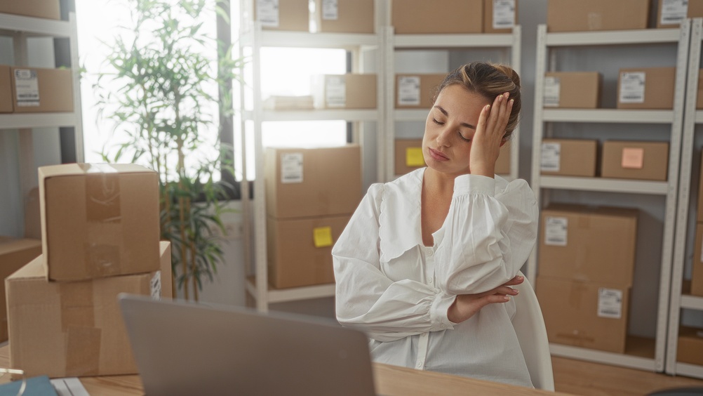 Small business owner surrounded by boxes of inventory
