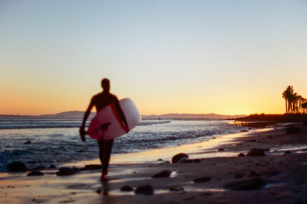 Man on beach with surfboard