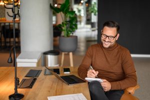 Remote worker with laptop and notepad