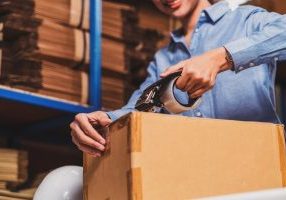 Woman packing box at warehouse space