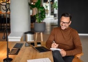 Remote worker with laptop and notepad